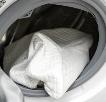 Kussensloop verwijderen en in de wasmachine doen